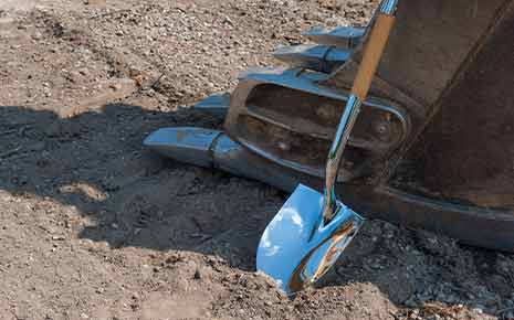 golden shovel, digger breaking ground, construction site