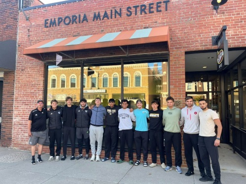 group photo of young men in front of a building that has a sign that reads "Emporia Main Street"